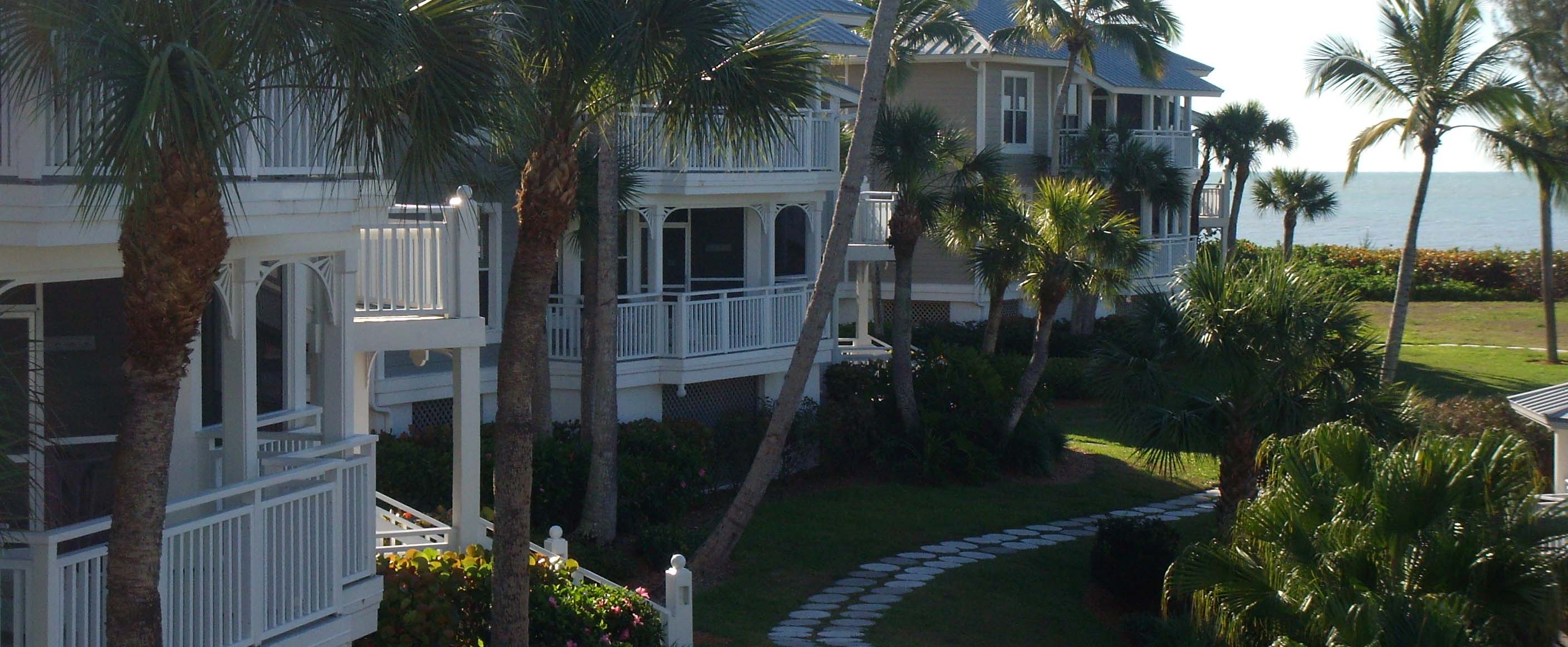 Sanibel Cottages framed by palms with the Gulf beyond